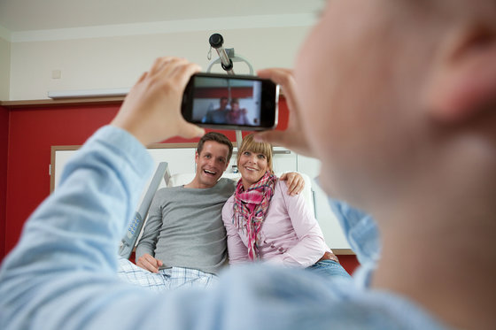 Blick durch ein Handy auf Vater und Tochter