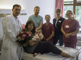 Gruppenfoto von der glücklichen Familie und dem Entbindungsteam