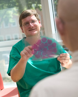Chefarzt Prof. Dr. Bernd Hertenstein im Gespräch mit einem Patienten.