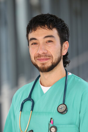 Portraitfoto David Saputera in grüner Dienstkleidung