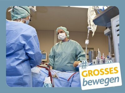 OP-Personal im OP-Saal in grün und mit Mundschutz und Haube