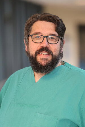 Portraitfoto Tobias Schmidt in grüner Dienstkleidung