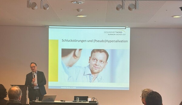 Hörsaal mit Vortragsleinwand und Dozenten