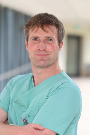Portraitfoto Kim Benjamin Mills in grüner Dienstkleidung