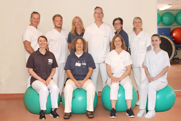 Zehn Physiotherapeuten und Physiotherapeutinnen stehen fast wie ein Mannschaftsfoto zusammen