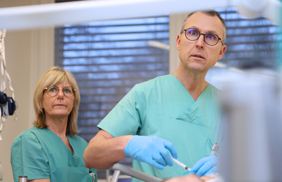 Ein Arzt führt mit medizinischen Instrumenten eine Behandlung am Patienten durch