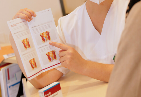 Ärztin mit Aufklärungsbogen im Patientengespräch