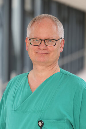 Portraitfoto Dr. Oliver Schunke in grüner Dienstkleidung