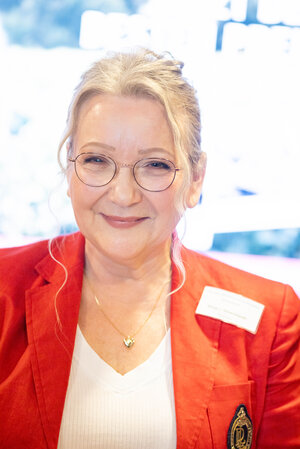 Portraitfoto Sonja von Glowczewski mit einem orangen Blaser über einem weißen Oberteil