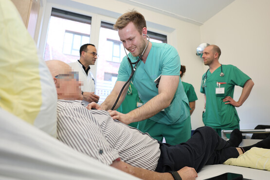 Untersuchung mit Patient im Bett