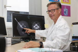 Prof. Lemke vor Bildschirm mit Röntgenbild