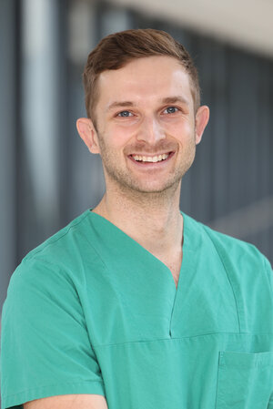 Portraitfoto Dr. Fabian Rings in grüner Dienstkleidung