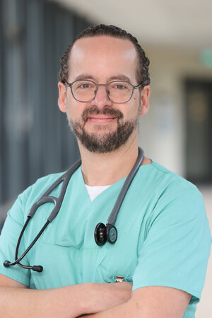 Portraitfoto Dr. Thees Schumacher in grüner Dienstkleidung